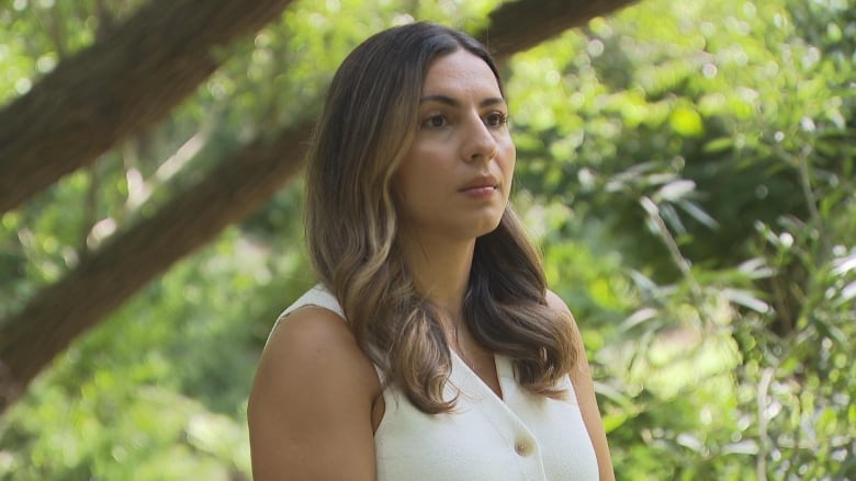 A woman stands in the middle of a creek.