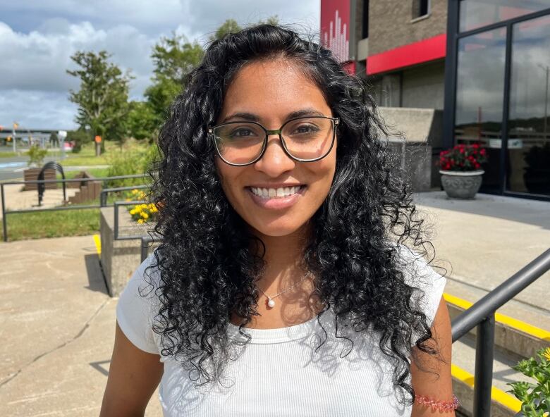 A woman with curly hair is smiling.