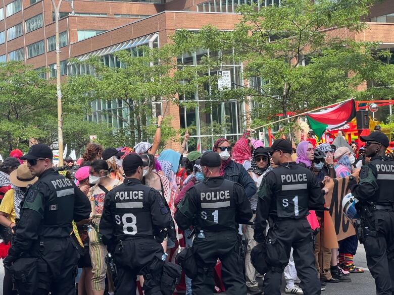 a group of protesters surrounded by police