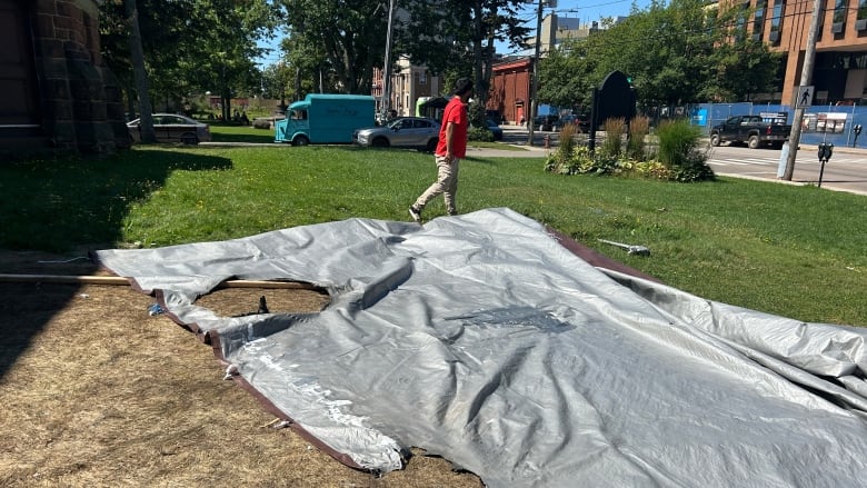 Grey tarp with burn marks.