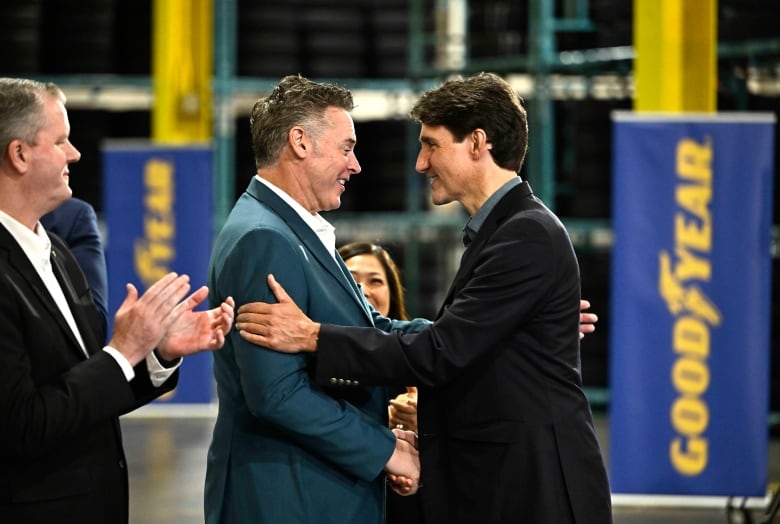 Prime Minister Justin Trudeau shakes hands with Mark Stewart, Chief Executive Officer and President of Goodyear, during Monday's announcement.