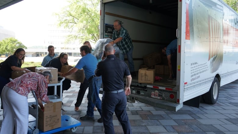 People loading off supplies from a truck.