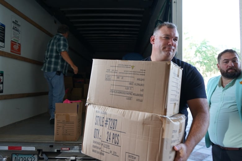 A man with boxes in his hand.