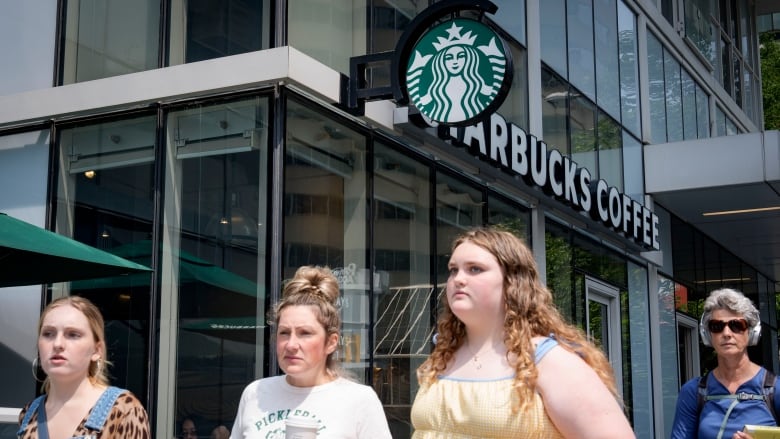 Four women are pictured outside a Starbucks cafe.