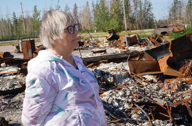 Woman looks out at rubble.