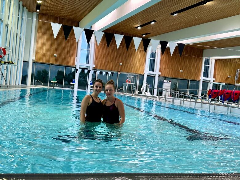 Two female lifeguards in a pool.