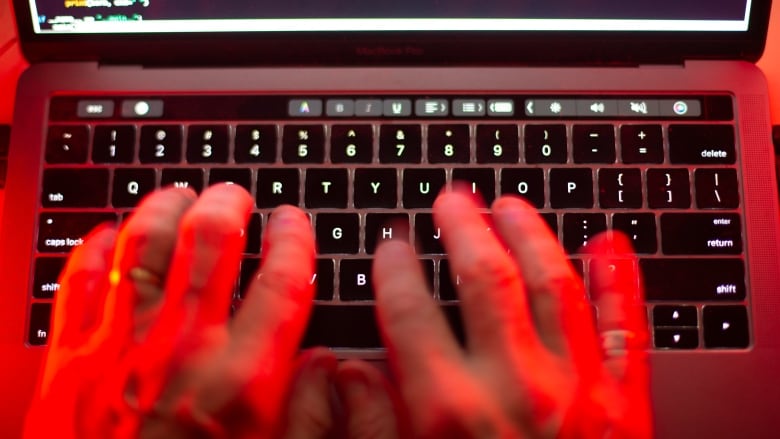 A person types on a laptop keyboard.