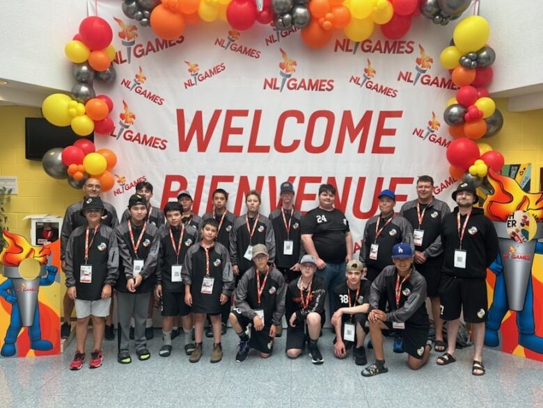 Group kids in black t-shirts standing in front of a balloon arch