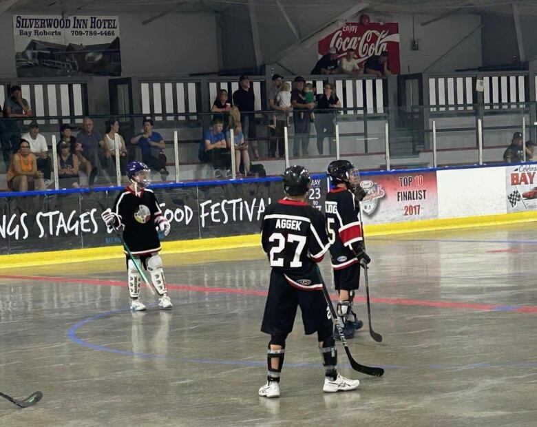 Three players in hockey gear with stick