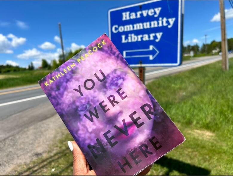 photo of book with Harvey Community Library sign in background