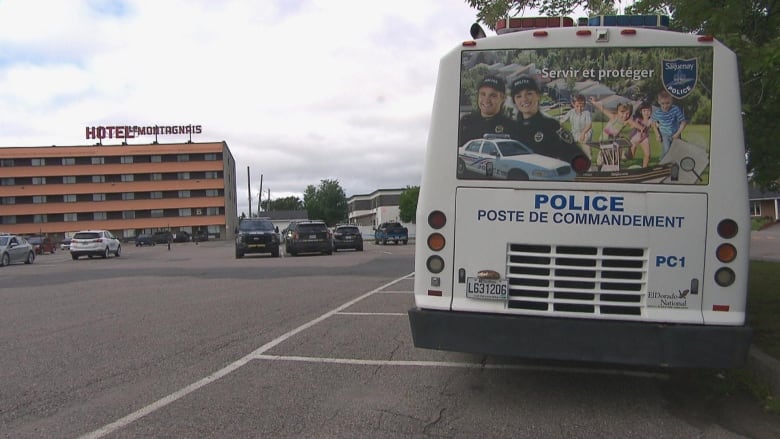 A police bus is stopped in front of a hotel 