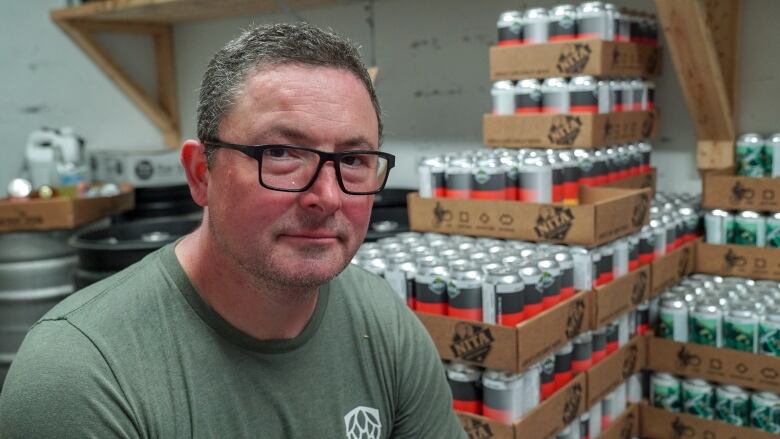 Andy Nita, owner of the Nita Beer Company in Ottawa, and cardboard flats of beer cans.