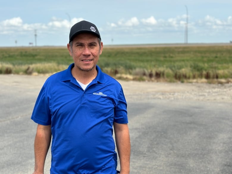 Portrait of Michael Van Tomme, wearing blue shirt and black cap