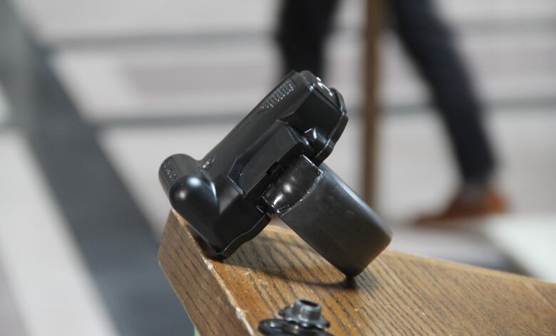 A black electronic monitoring device is displayed on the corner of a wooden podium.