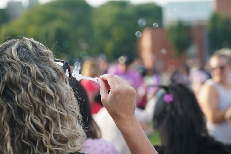 A woman blows bubbles at Wednesday's vigil. 