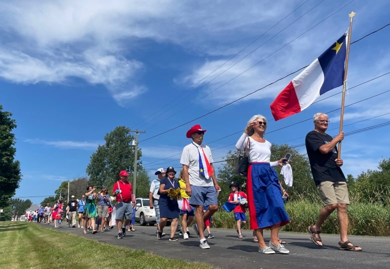 a group of citizens take part in a tintamarre dressed in bright colors