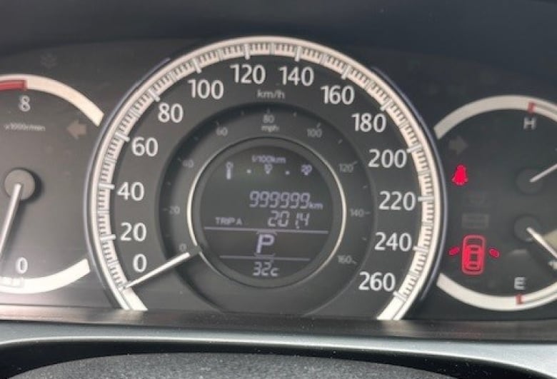 A car dashboard with an odometer reading 999,999 km.