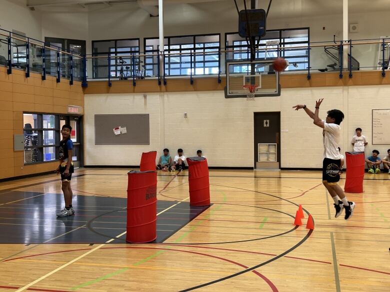 Young boys playing basketball in a gym court. 