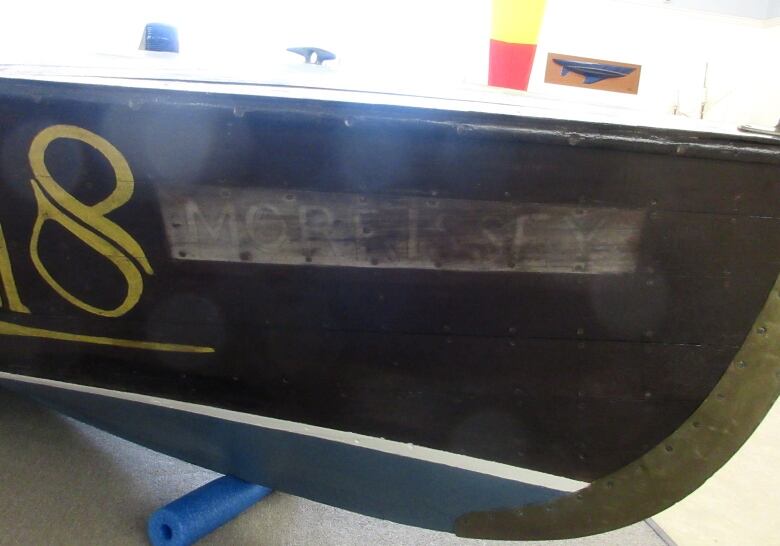 Faded letters on a dark wood boat read 'Morrissey.'