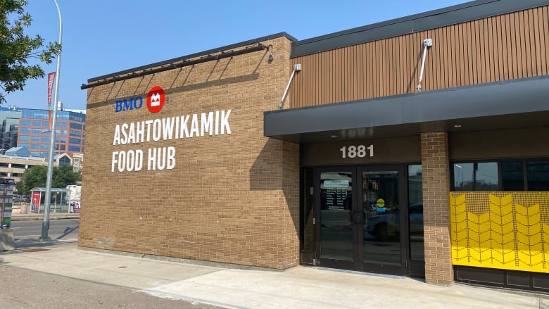 A brick builiding with a sign on it in an Indigenous language is in full view.