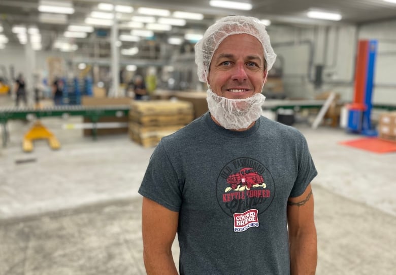 a man in a hair net stands in a warehouse