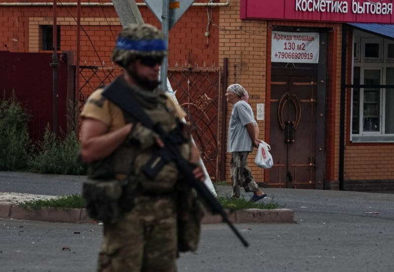 A Ukrainian soldier is seen patrolling an area in a Ukraine-controlled part of Sudzha, Russia, on Friday.