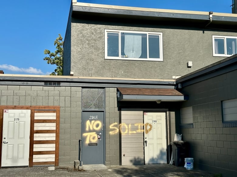 An industrial building with the words 'No to Solid' spray painted on it. 