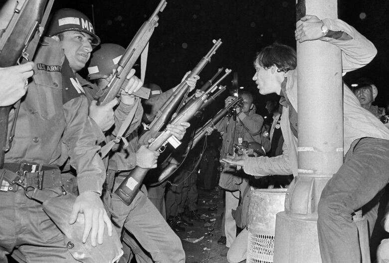 Standoff in black and white photo between cops and protesters