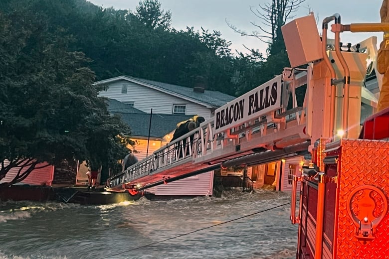 Rescuers save people from an inn during extreme flooding.