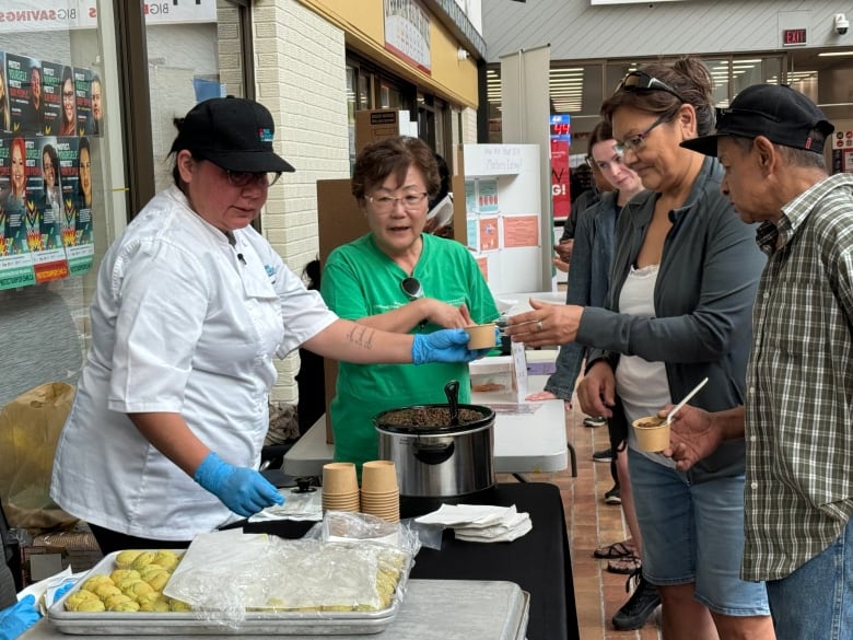 Roxanne Kent (left) of the Prairie Research Kitchen and Miyoung Suh (centre) explain the use of kale in chili and cornbread muffins to Linda Scott and Perry Sinclair.