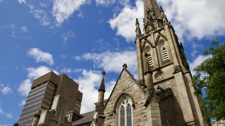 A stone church seen from a low angle against a backdrop of blue sky.