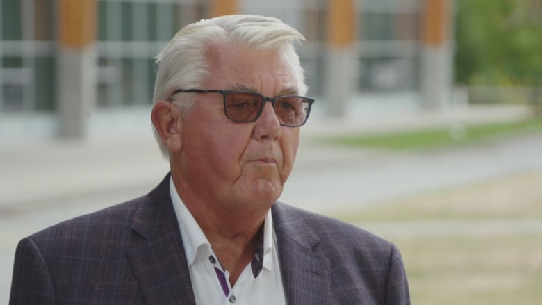 A man in a suit and tinted glasses. 