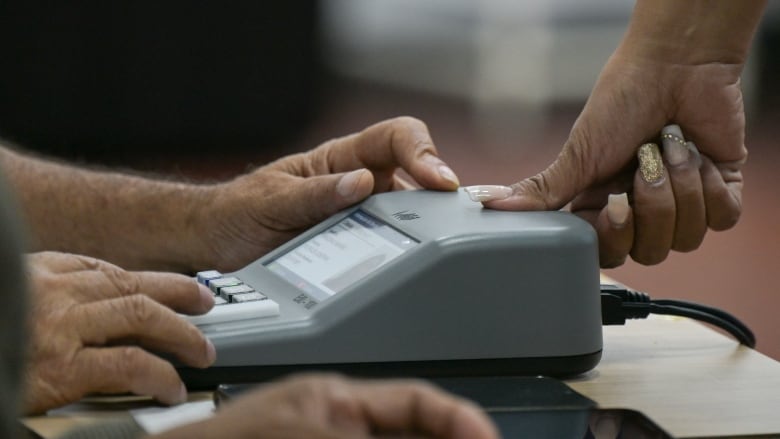 Someone getting their finger scanned on a fingerprint scanner.