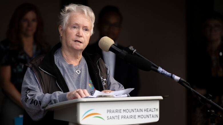 A woman speaks at a podium.