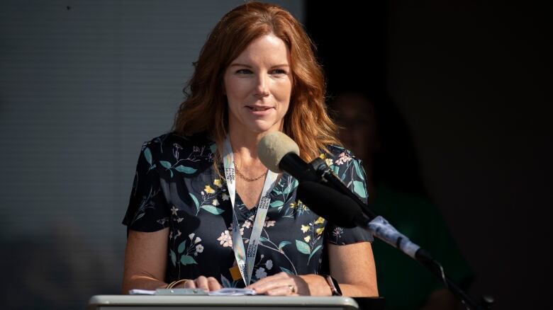 A woman speaks at a podium.