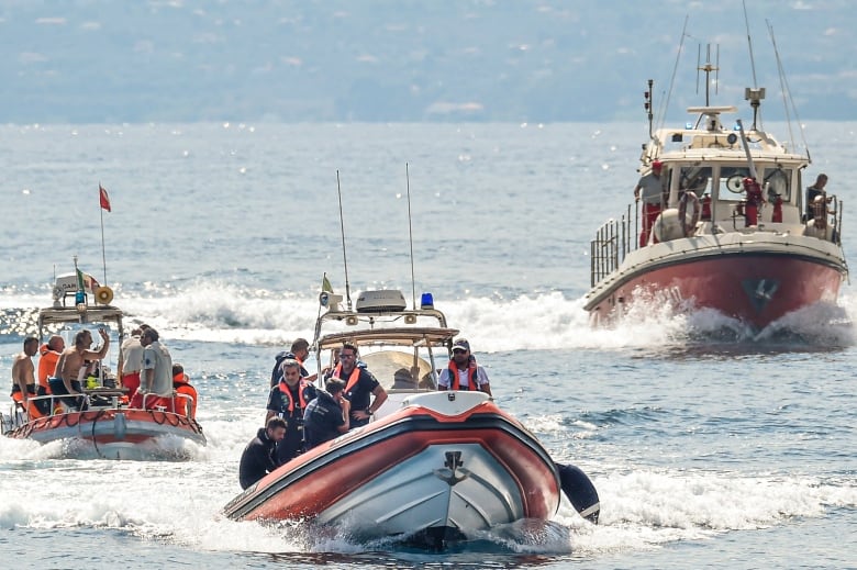 Three boats are seen patrolling a large body of water.