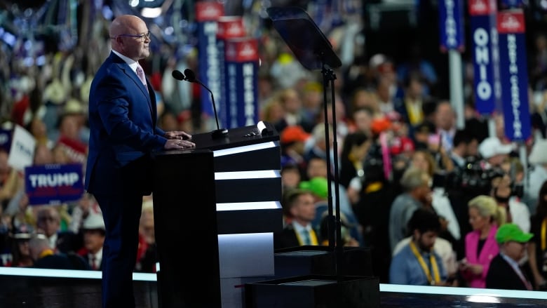 A man stands at a podium while addressing a crowd.