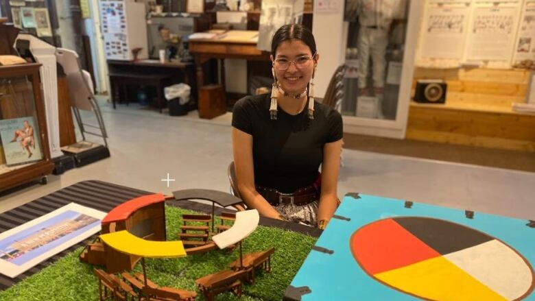 A girl sitting in a museum smiling at the camera. 