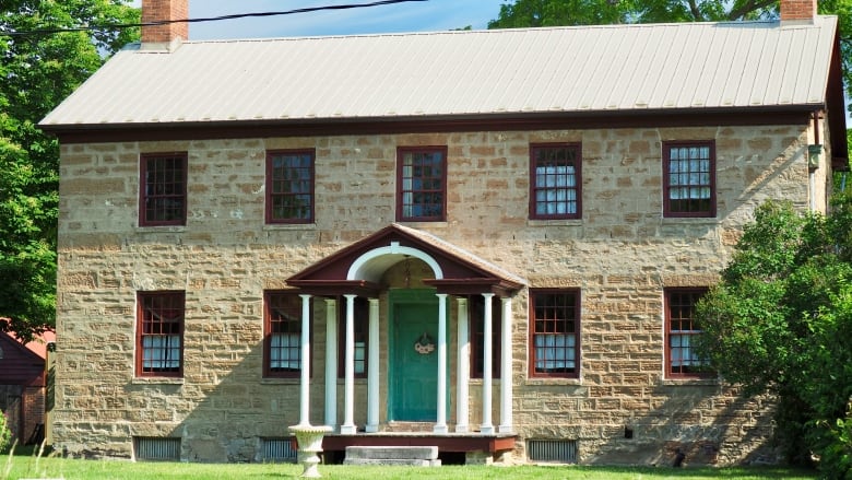 A Georgian style manor with about 10 large windows on its front.