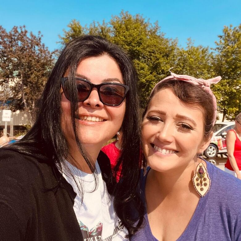 Two women smile at the camera 