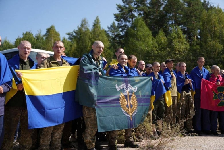 Men hold up a flag.