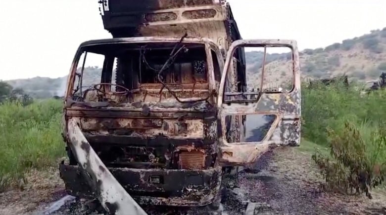 A charred, empty vehicle is shown. 