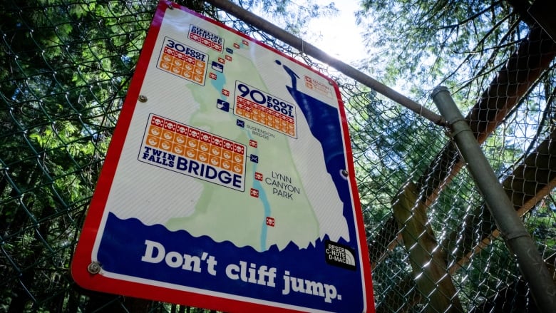 A sign reading, 'Don't cliff jump' is posted on a fence.