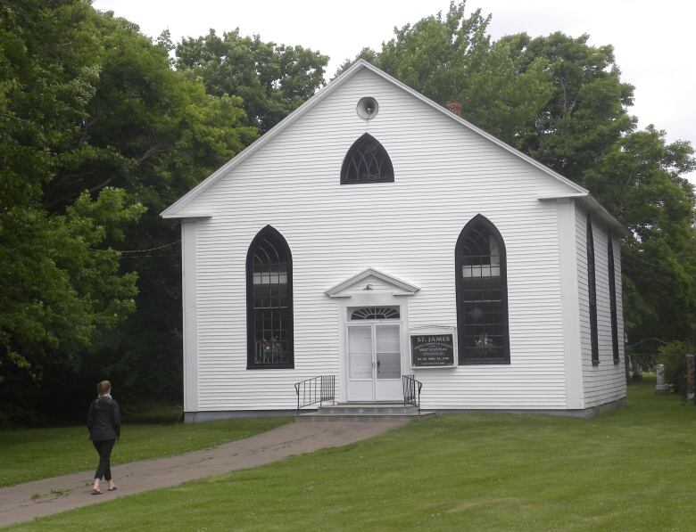 West Covehead United Church in summer, with a person on the walk approaching the front door.