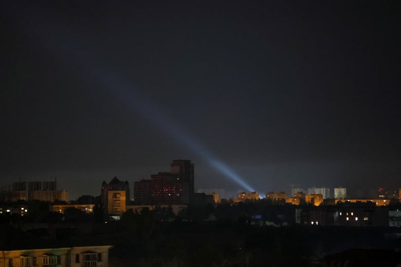 A spotlight is seen shining above Kyiv, amid a Russian air attack on the Ukrainian capital.