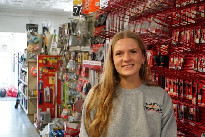 Carly Woods standing in a store aisle filled with sawblades