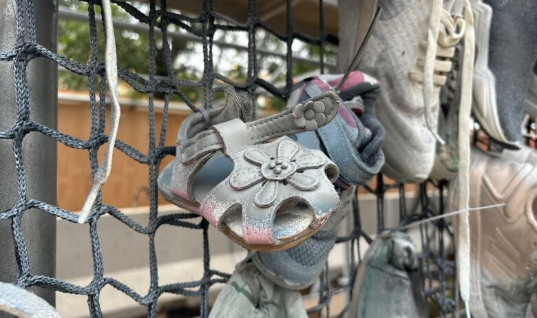 Children's shoes hanging on a net