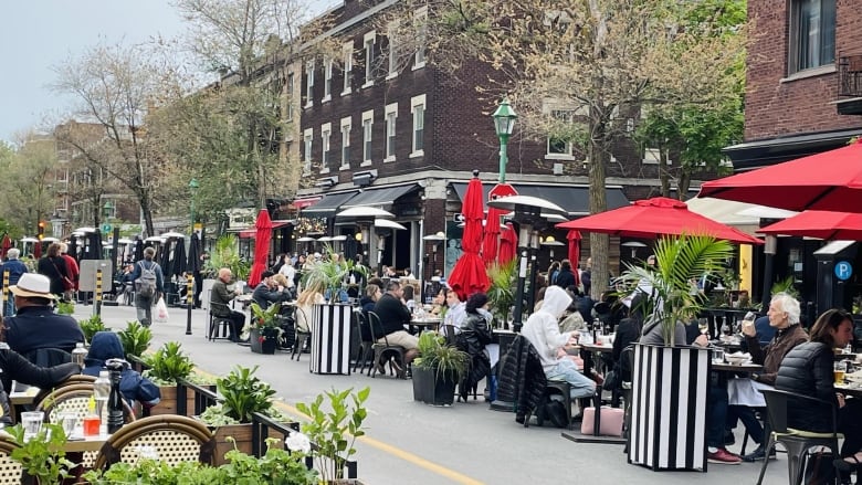 People dining outside restaurants on patios. 