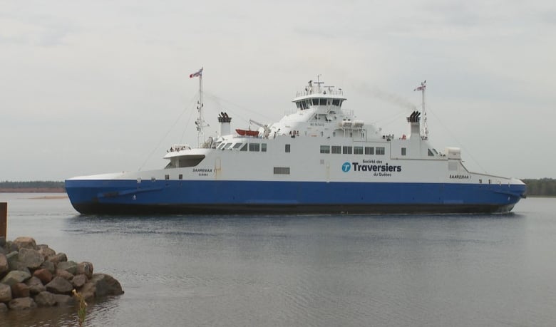 MV Saaremaa on the water with rock pier in foreground.