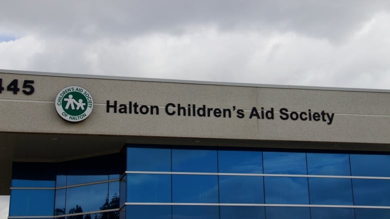 A modern office building with a sign reading 'Halton Children's Aid Society.'